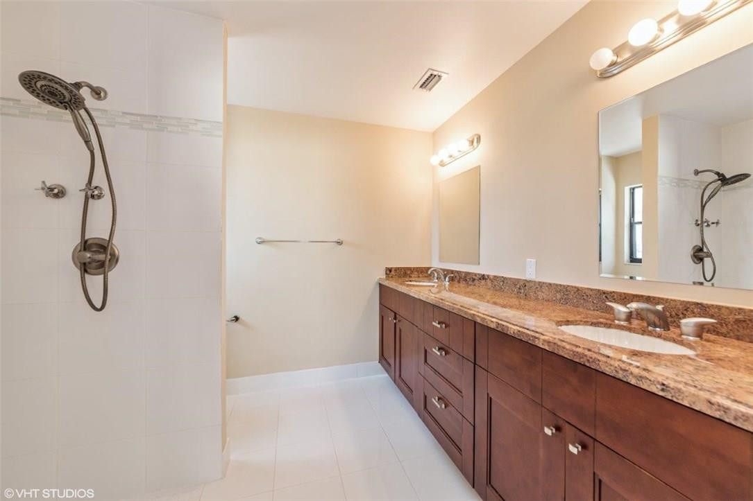 22494 Grouper Court Boca Raton, FL 33428 - Photo 11 of 22 a bathroom with a granite countertop sink a mirror and a shower
