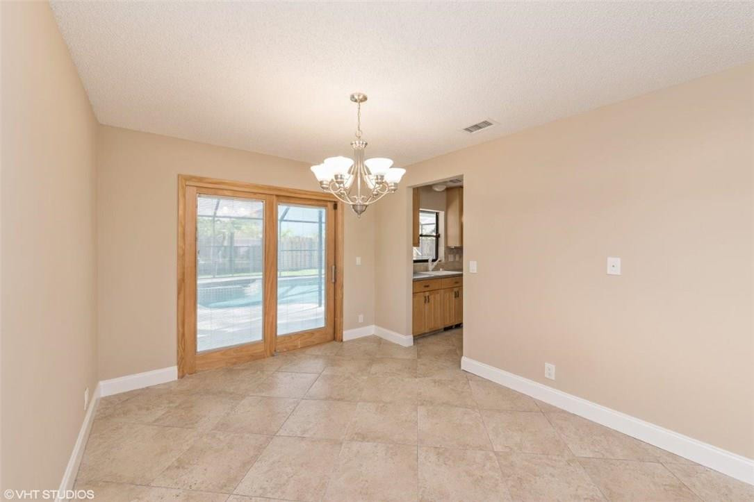 22494 Grouper Court Boca Raton, FL 33428 - Photo 5 of 22 a view of an empty room with window and chandelier