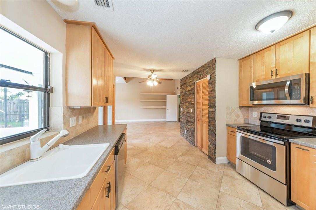 22494 Grouper Court Boca Raton, FL 33428 - Photo 7 of 22 a kitchen with stainless steel appliances granite countertop a sink stove and refrigerator