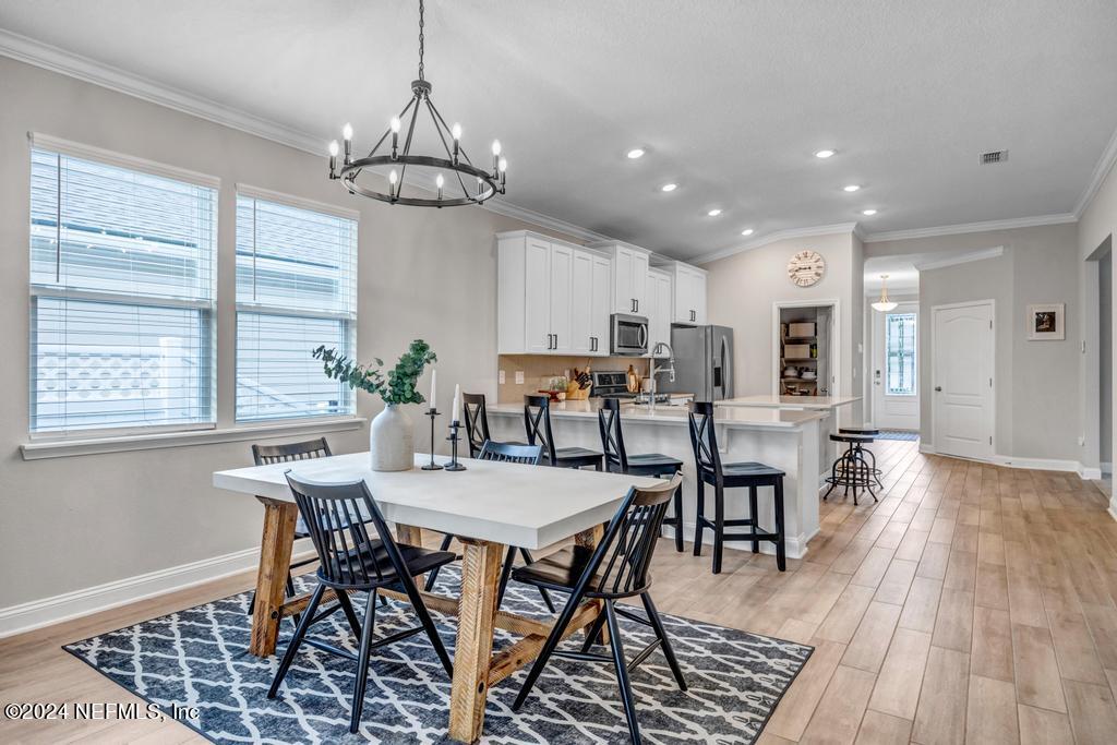 196 Creekmore Drive St. Augustine, FL 32092 - Photo 15 of 51 a view of a dining room with furniture window and wooden floor