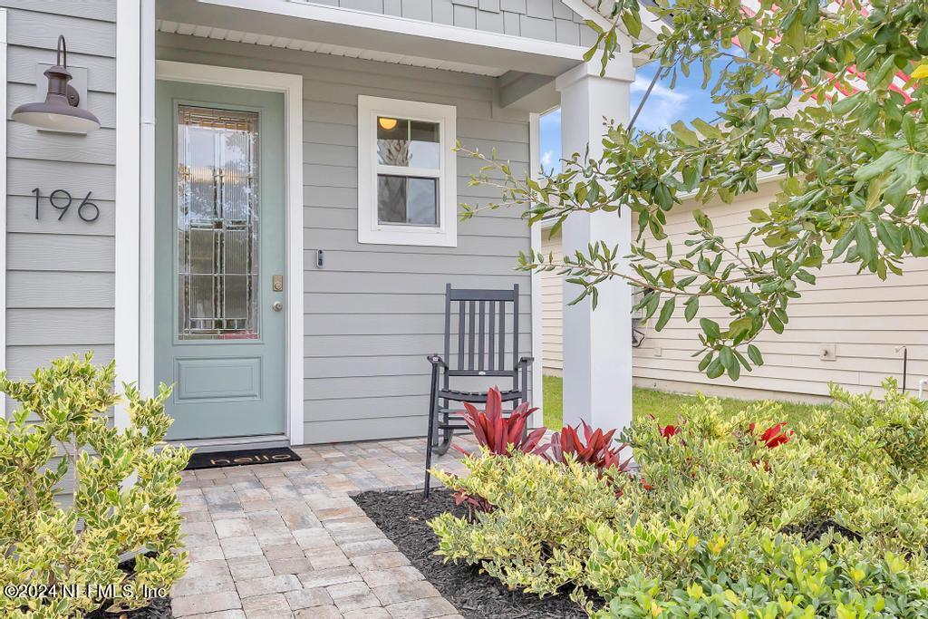 196 Creekmore Drive St. Augustine, FL 32092 - Photo 2 of 51 a front view of a house with a yard and flowers