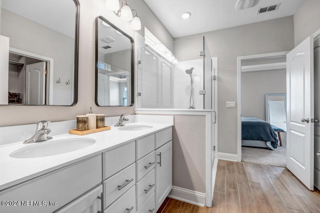 196 Creekmore Drive St. Augustine, FL 32092 - Photo 28 of 51 a en suite bathroom with a double vanity sink and a mirror