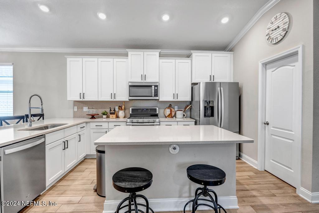 196 Creekmore Drive St. Augustine, FL 32092 - Photo 7 of 51 a kitchen with stainless steel appliances granite countertop a sink a stove a refrigerator cabinets and chairs
