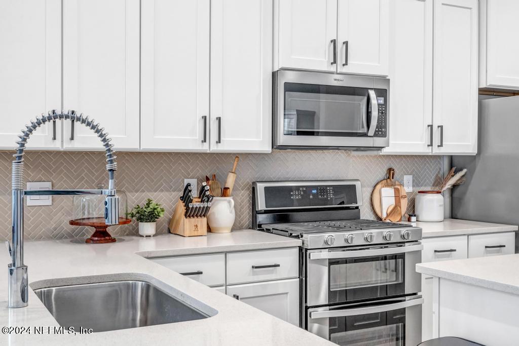 196 Creekmore Drive St. Augustine, FL 32092 - Photo 8 of 51 a kitchen with granite countertop a stove and a sink