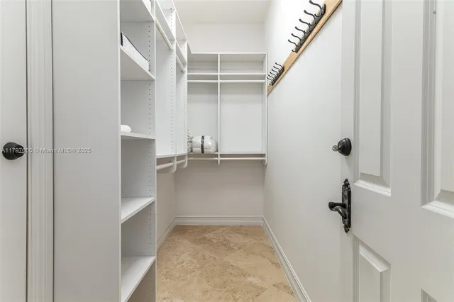 a view of walk in closet with empty racks