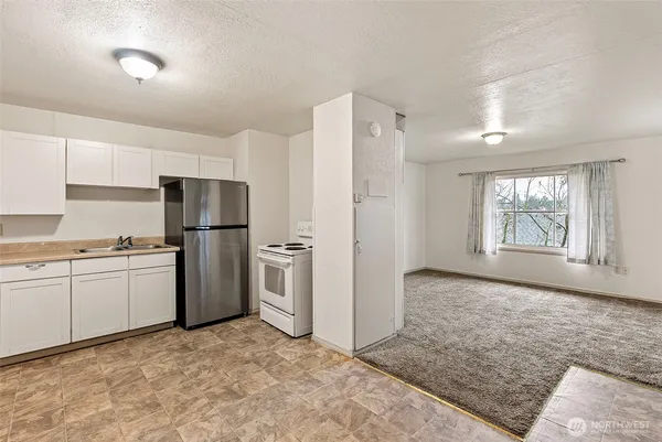 a kitchen with refrigerator and cabinets