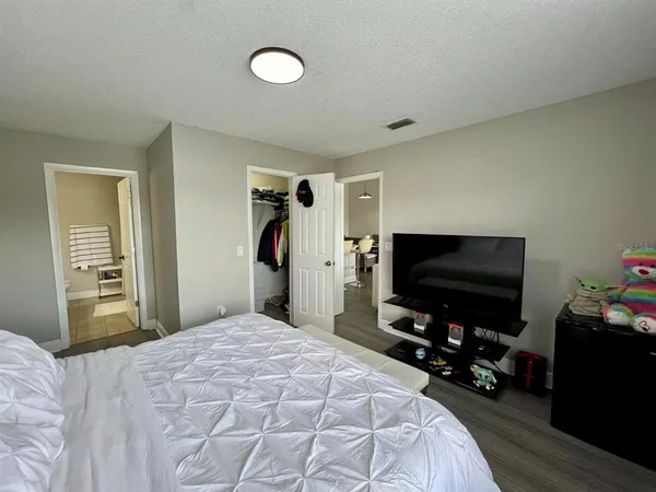 a bed sitting in a bedroom next to a window with pc on the table