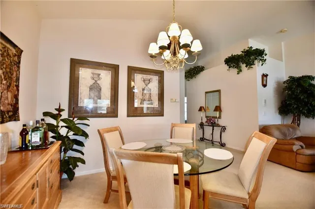 a dining room filled chandelier and kitchen view
