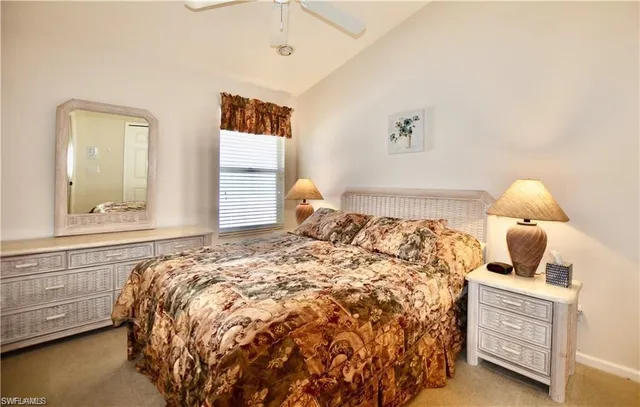 a large bed sitting in a bedroom next to a window and a chandelier