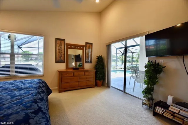 a bedroom with a bed and large windows