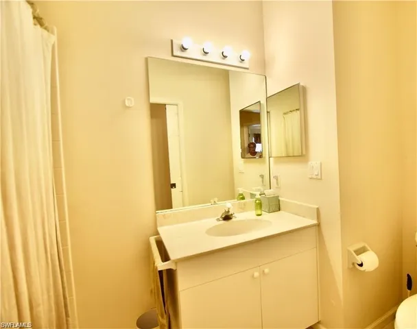 a bathroom with a sink mirror and a shower