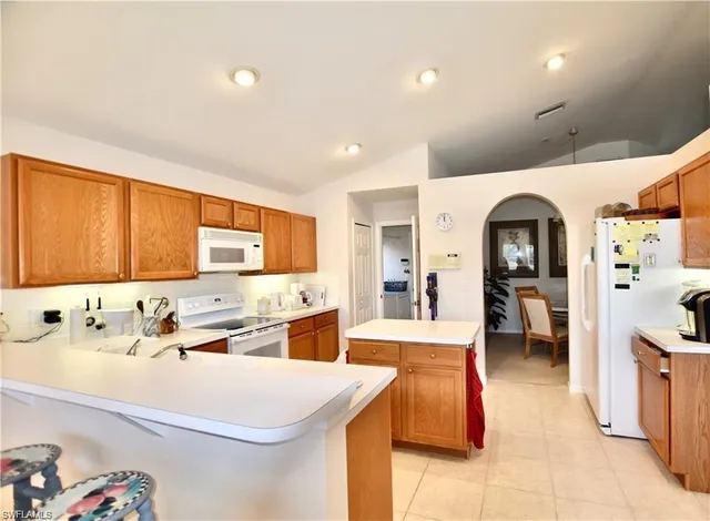 a large white kitchen with a sink and cabinets