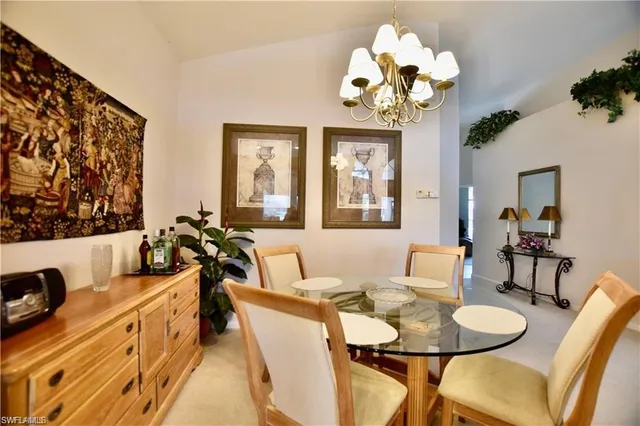 a view of a dining room with furniture a chandelier and a window