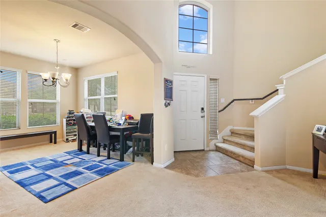 a kitchen with stainless steel appliances kitchen island granite countertop a refrigerator a stove a sink a dining table and chairs