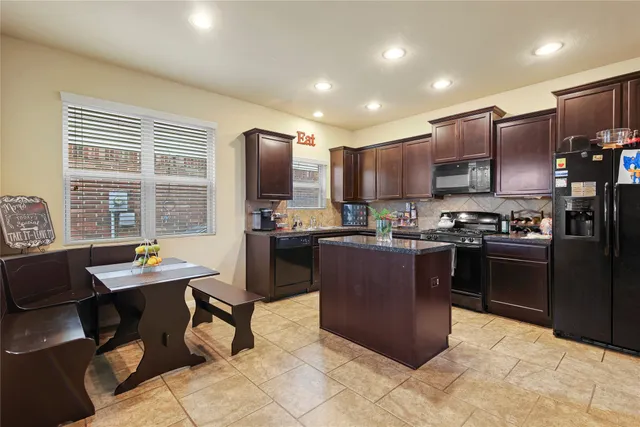 a kitchen with kitchen island granite countertop a sink counter top space appliances and a window