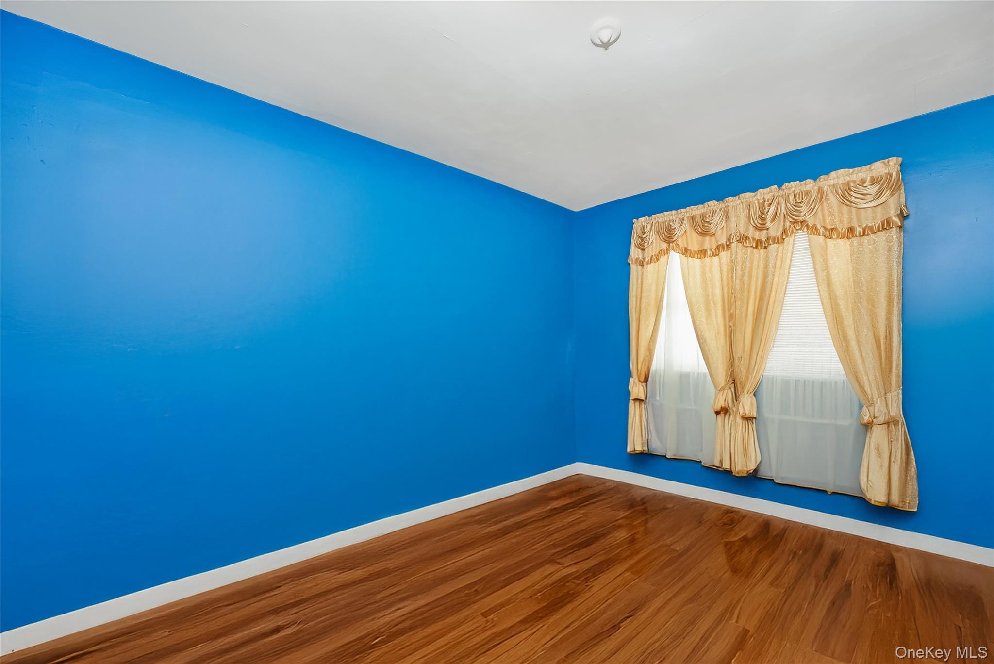 24 Bay 3rd Street Islip, NY 11751 - Photo 9 of 27 a view of empty room with wooden floor and fan
