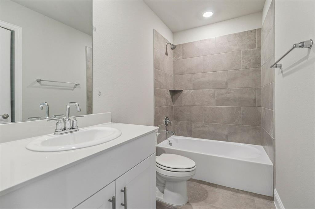 2219 Rannoch Street Sherman, TX 75092 - Photo 28 of 32 a bathroom with a bathtub a sink a toilet and a mirror