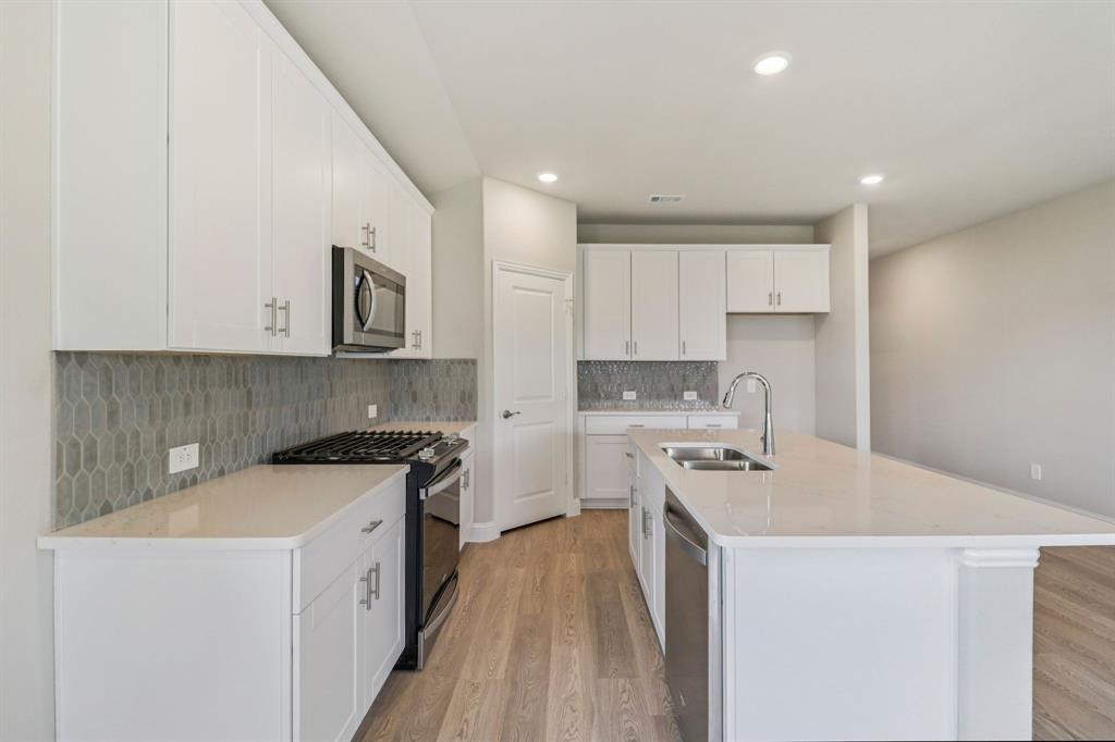 2219 Rannoch Street Sherman, TX 75092 - Photo 3 of 32 a kitchen with a sink stove top oven and cabinets