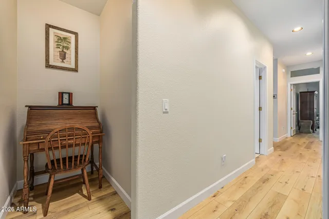 a view of a hallway to a room with wooden floor and furniture