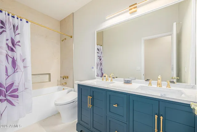 a bathroom with a double vanity sink toilet mirror and shower