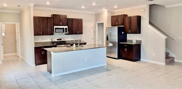 a kitchen with stainless steel appliances granite countertop a refrigerator and a stove