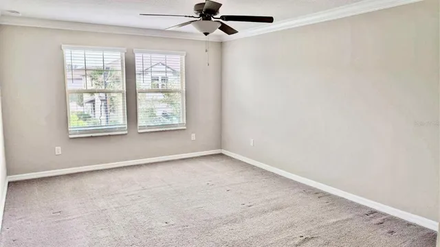 an empty room with windows and fan