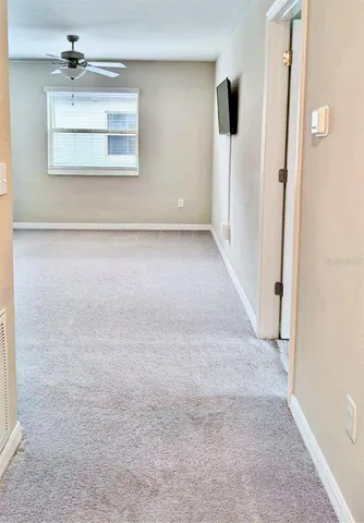 an empty room with staircase and windows