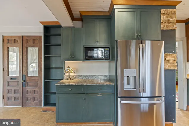 a kitchen with granite countertop a refrigerator and a sink