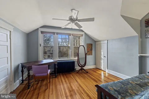 a living room with furniture a large window and wooden floor
