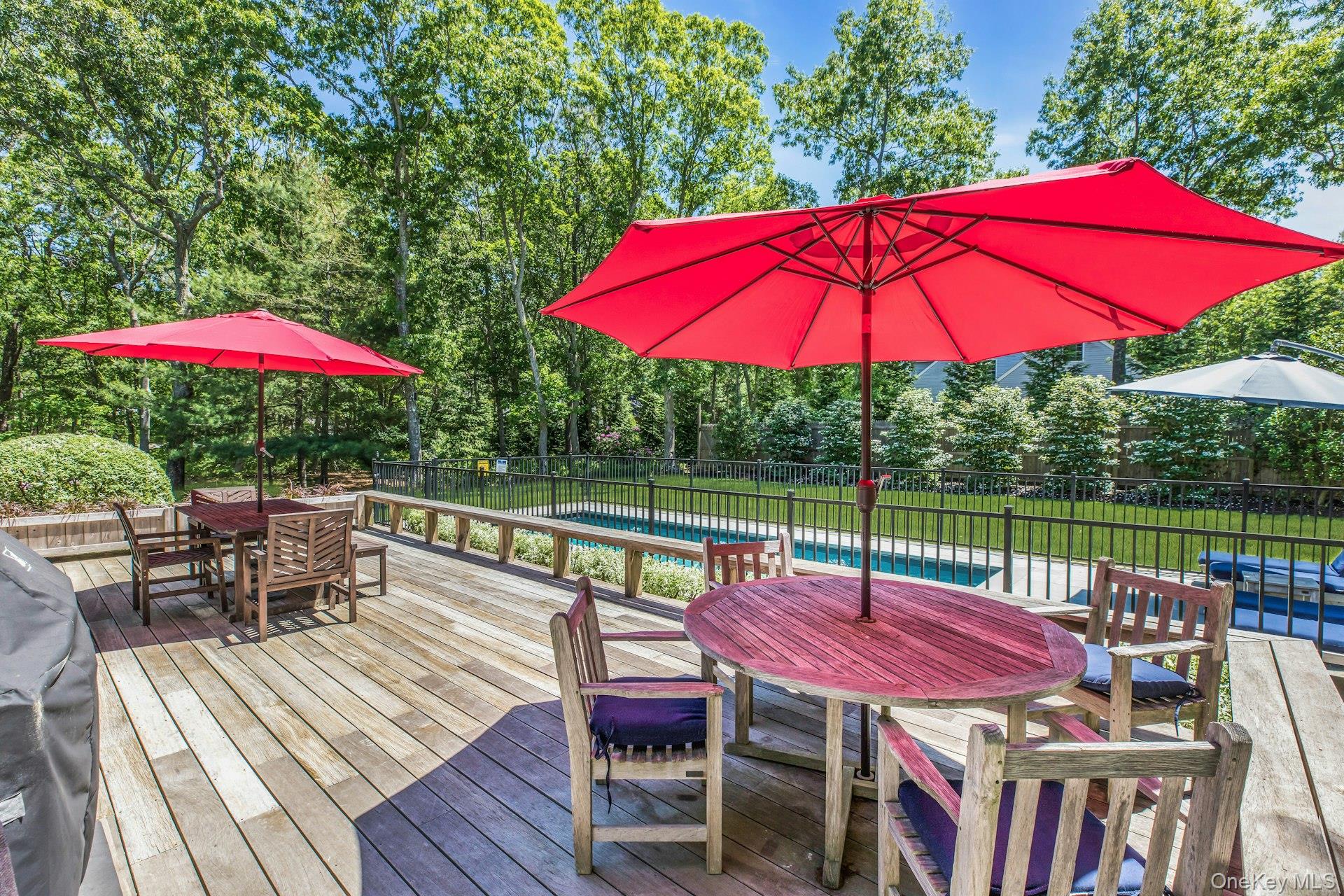 16 Hildreth Road Hampton Bays, NY 11946 - Photo 25 of 29 an outdoor sitting area with red umbrella a swimming pool and outdoor seating
