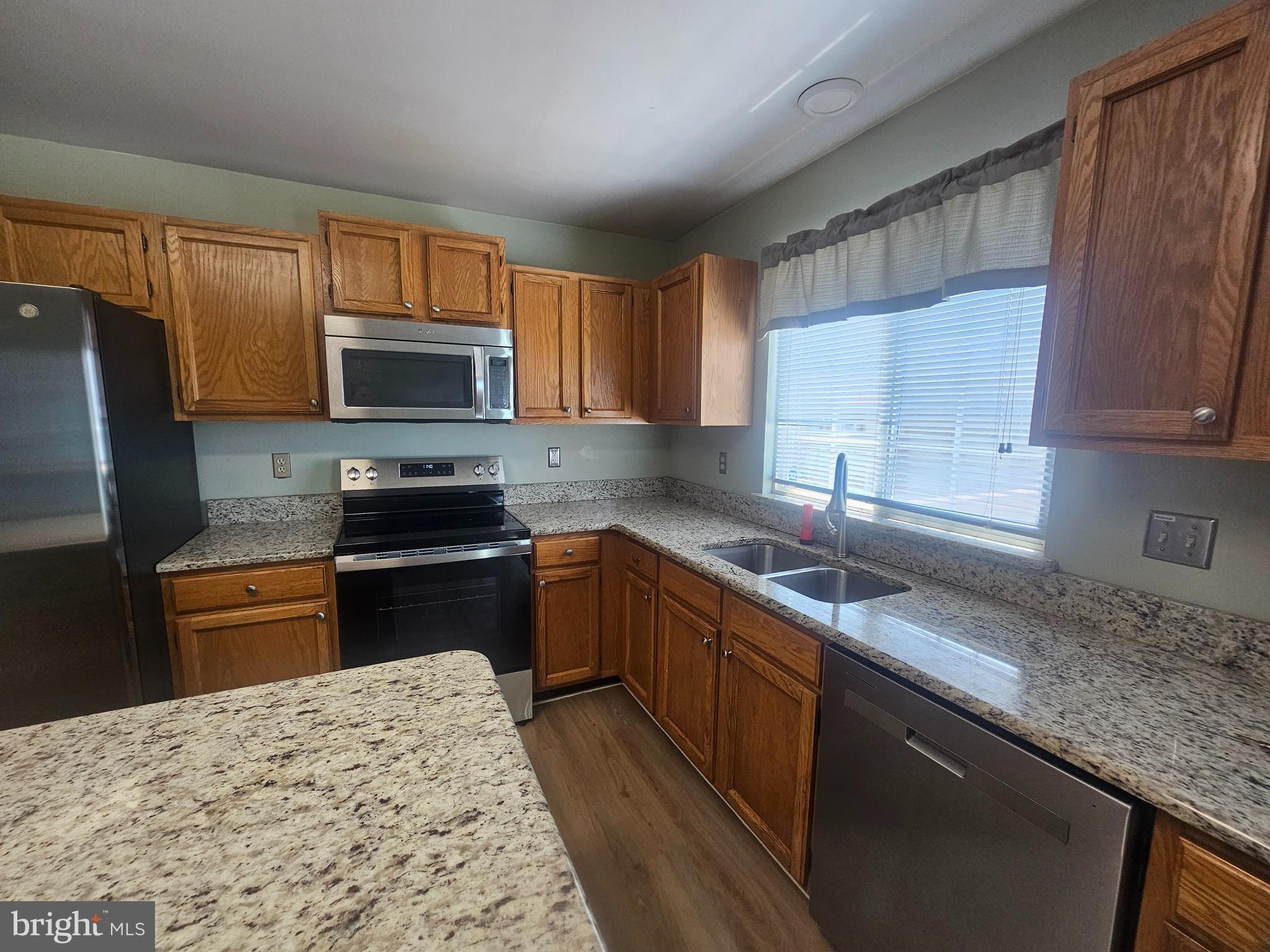 13 Denny Circle Newark, DE 19702 - Photo 6 of 18 a kitchen with stainless steel appliances granite countertop a sink stove microwave and refrigerator