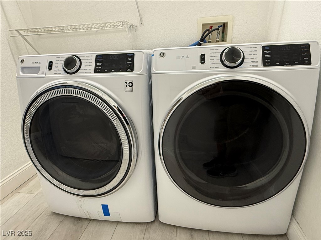 7062 Russell Ranch Avenue Las Vegas, NV 89113 - Photo 23 of 32 Laundry room featuring laundry area, washer and clothes dryer, and wood finish floors