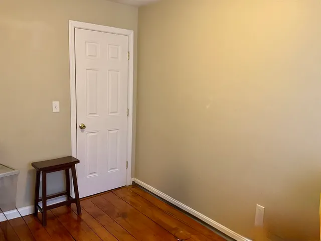 a view of a small space with wooden floor and a window