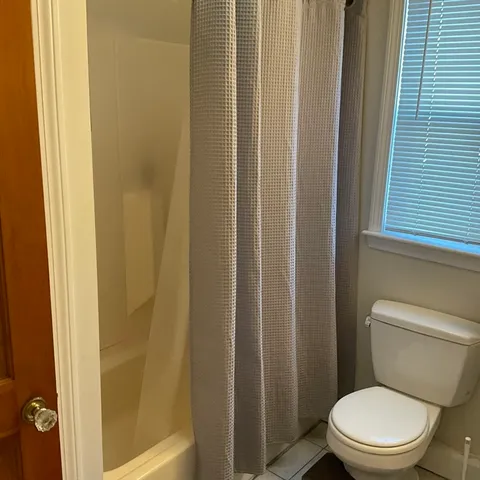 a white toilet sitting next to a shower
