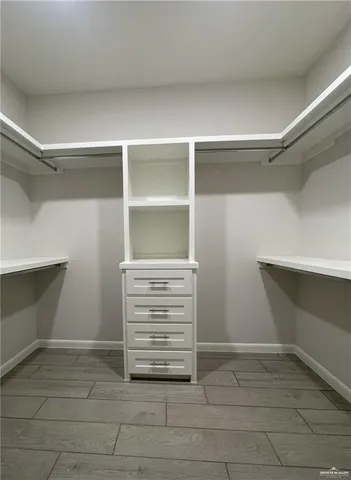 a view of walk in closet with empty racks