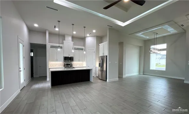 a large room with a large window and stainless steel appliances