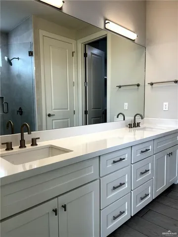 a bathroom with double vanity sink and a mirror