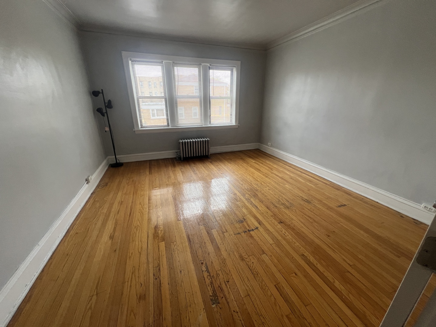 1439 West 93rd Street, Unit 1 Chicago, IL 60620 - Photo 2 of 4 an empty room with wooden floor and windows