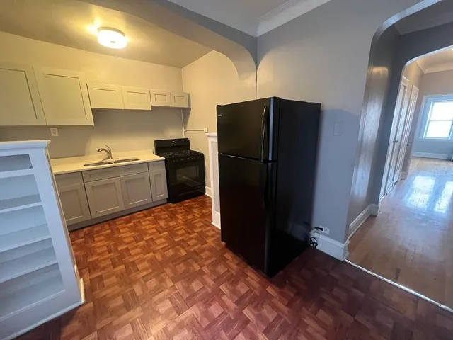 a kitchen with granite countertop a refrigerator and a sink