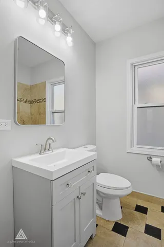 a bathroom with a toilet a sink and mirror
