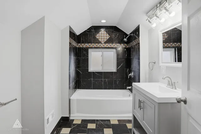 a bathroom with a sink a bathtub and a mirror