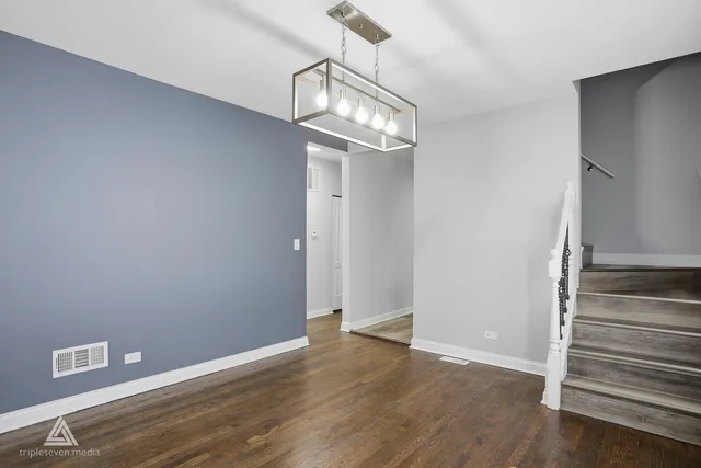 a view of a hallway with wooden floor and a chandelier