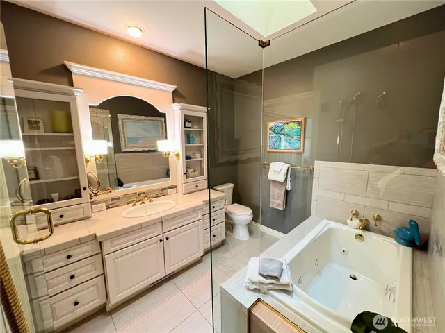 a spacious bathroom with a granite countertop sink mirror and bathtub