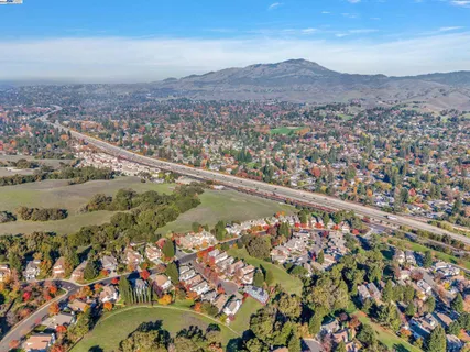 a view of a house with a small yard and wooden floor and fence