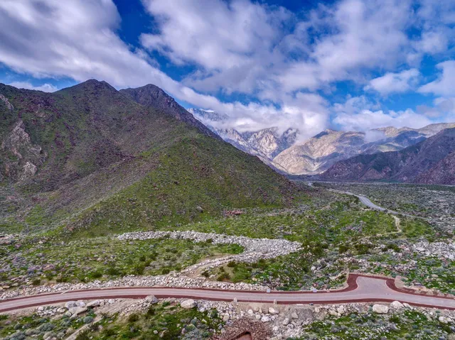a view of a lush green field with mountains in the background