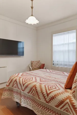 a large bed sitting in a bedroom next to a window