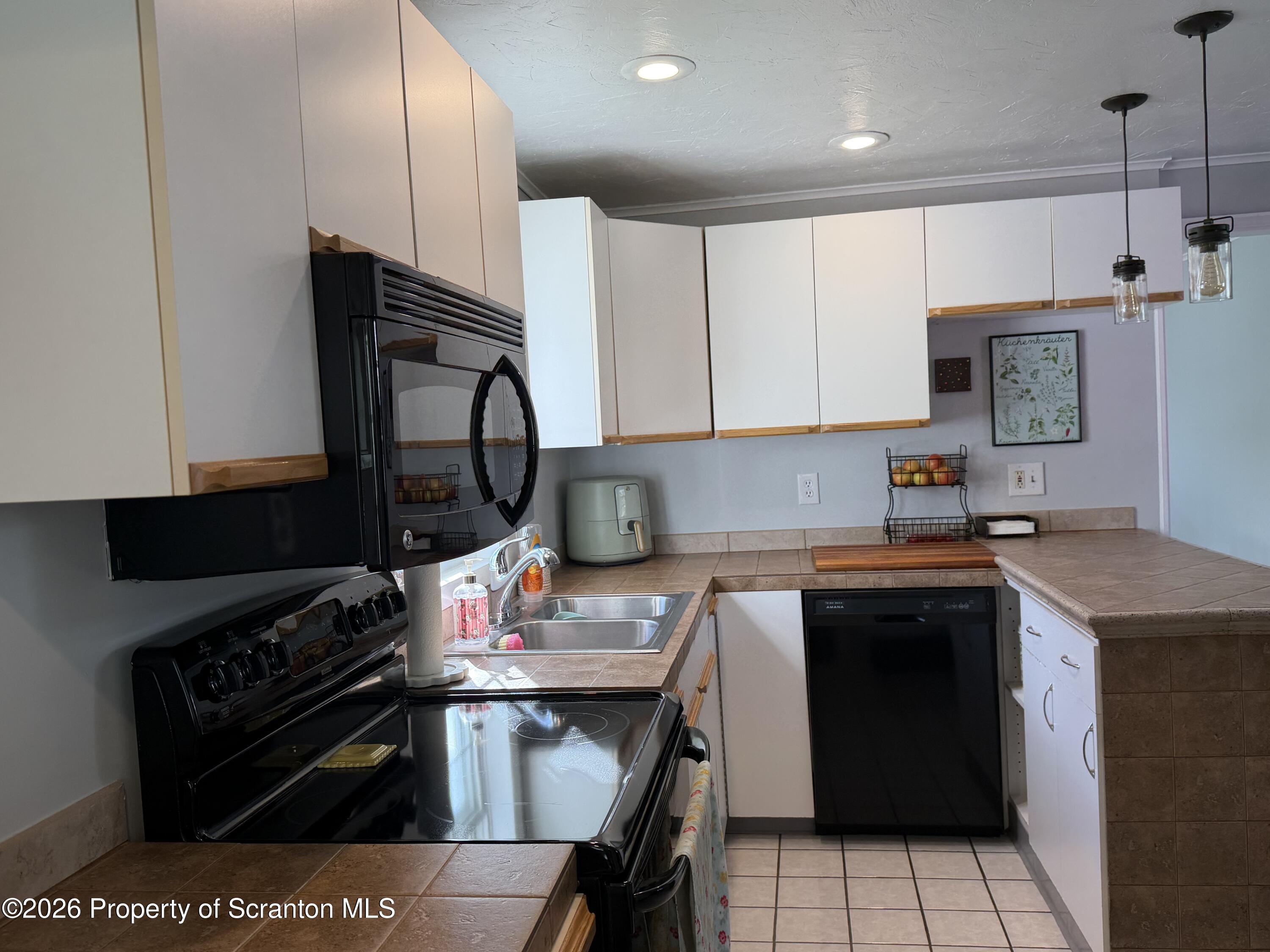 320 Haverly Street Throop, PA 18512 - Photo 6 of 27 a kitchen with a stove a sink and a microwave