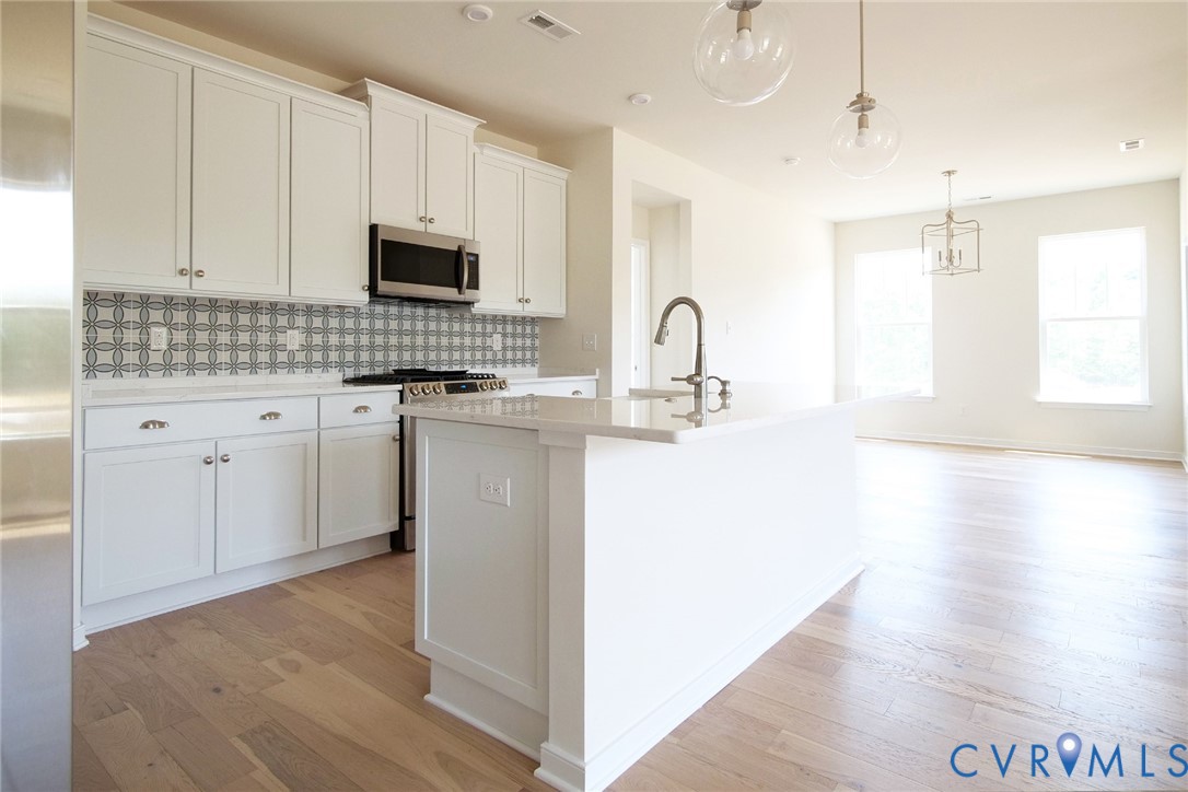 16012 Canoe Pointe Loop Moseley, VA 23120 - Photo 2 of 3 a kitchen with stainless steel appliances granite countertop a sink a stove a microwave a sink a refrigerator and white cabinets