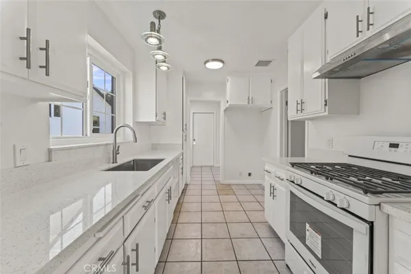 a kitchen with white cabinets and sink