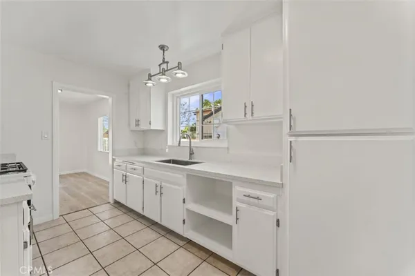 a kitchen with stainless steel appliances granite countertop a stove a refrigerator and a white cabinets